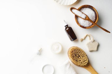 Spa güzellik cilt bakımı flamock-up vücut fırçası ve serum ve tuz ile kase ile beyaz arka plan üzerinde yatıyordu. Üstte görüntü