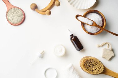 Spa güzellik cilt bakımı flamock-up vücut fırçası ve serum ve tuz ile kase ile beyaz arka plan üzerinde yatıyordu. Üstte görüntü