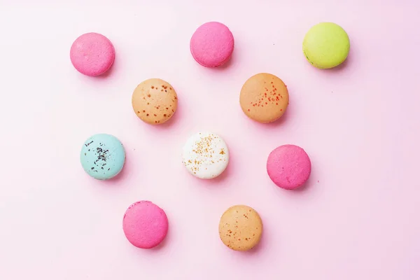 sweet colorful macaroons on pink background. Top view