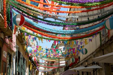 Lizbon, Portekiz - 2 Eylül 2019: Bairro-Alto bölgesindeki eski şehrin sokaklarında geleneksel binalar arasında asılı duran çelenkler