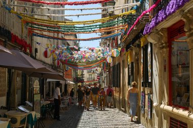 Lizbon, Portekiz - 2 Eylül 2019: Bairro-Alto bölgesindeki eski şehrin sokaklarında geleneksel binalar arasında asılı duran çelenkler