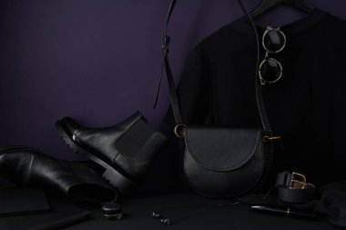 Deri çantalı Chelsea Botları ve koyu renkli kompozisyon düzenlenmiş tişört, yakın görüş.  