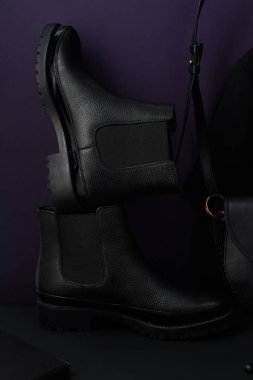 Deri çantalı Chelsea Botları ve koyu renkli kompozisyon düzenlenmiş tişört, yakın görüş.  