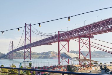 Lizbon, Portekiz - 28 Ağustos 2019: Lx Factory 'deki çatı katından 25 Nisan köprüsü ve Tagus nehri manzarası