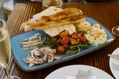 Geleneksel Portekiz deniz ürünleri restoranda ekmek ve salata ile servis edilir.