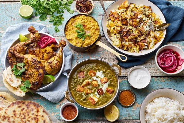 Hint mutfağında, biryani ve kırmızı körili tandır tavuğu pilav naan ve ahşap arka planda basmati pilavlı palak paneer.