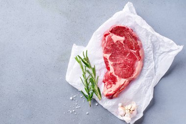 Siyah Angus bifteği. Biberiye ve sarımsaklı parşömen kağıdında barbekü için hazır. 