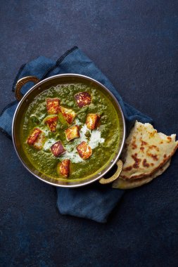 Yumuşak peynirli vejetaryen palak paneer marşı ve beton arka planda ıspanak, Hint mutfağı konsepti.