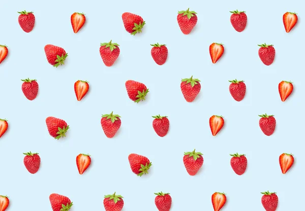 Top view creative pattern with ripe red strawberries on blue background, close view