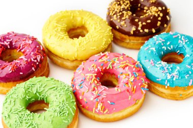 Beyaz arka planda tatlı renkli donutlar. Abur cubur üstü görünümü  
