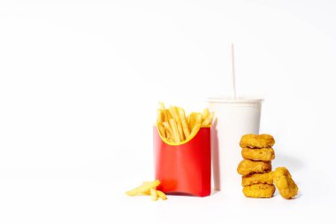 Kutuda kızarmış patates kızartması ve beyaz arka planda izole edilmiş plastik bardakta içkili tavuk nugget. 