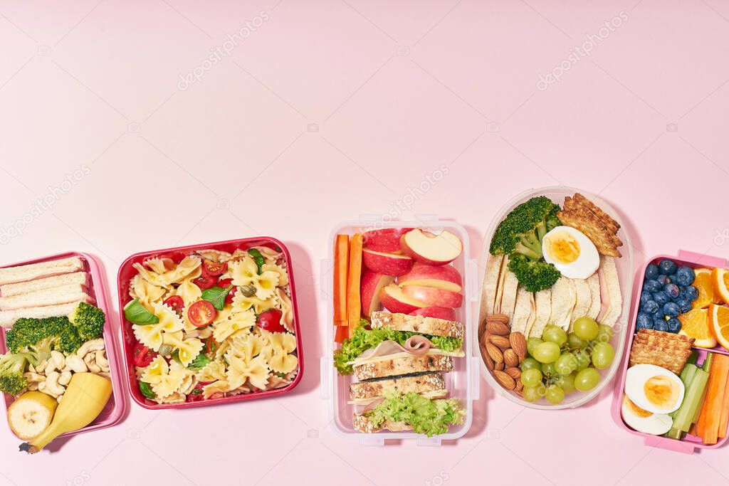 Top view pattern of school lunchboxes with various healthy nutritious meals on pink background