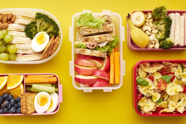 Вид Сверху Школьные Обеды Различными Здоровыми Питательными Блюдами Желтом Фоне — стоковое фото