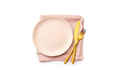 Düz pembe boş tabak bez ve altın çatal bıçak ile beyaz arka plan, üst görünüm izole