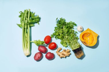 Mavi arka planda vejetaryen yemeği malzemeleri olan yaratıcı bir düzen. Sağlıklı beslenme kavramı