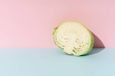 Pastel renkli arka planda yarım lahana. Vejetaryen yemek malzemeleri..