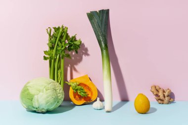 Pembe arka planda tereyağlı pırasa ve kerevizli lahana. Sağlıklı diyet kavramı.