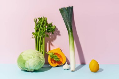 Pembe arka planda tereyağlı pırasa ve kerevizli lahana. Sağlıklı diyet kavramı.