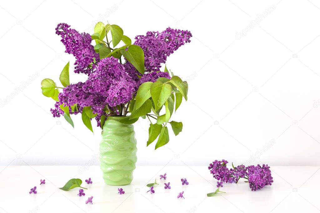 Bunch of fresh  violet Syringa vulgaris in Lilac flower  in green ceramic vase.Creative concept.