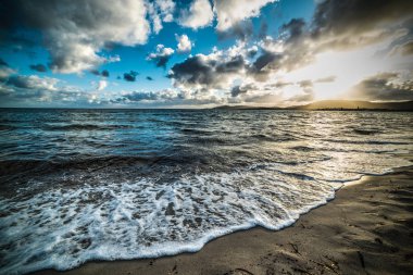 Gün batımında denize karanlık bulutlar. Alghero, İtalya