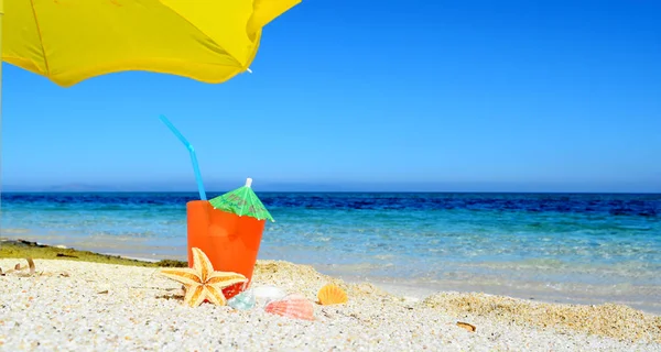 沙滩上的黄色阳伞下的鸡尾酒 — 图库照片
