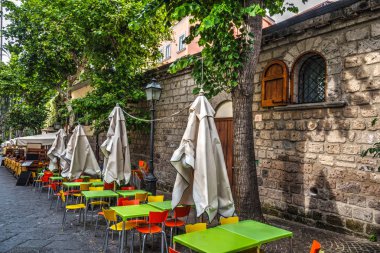 Yemek masaları ve sandalyeleri dünya ünlü Sorrento pitoresk bir sokakta. Amalfi coast, İtalya
