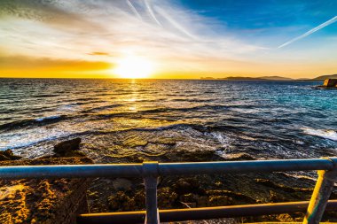Alghero sahilinde renkli bir gün batımı. Sardunya, İtalya