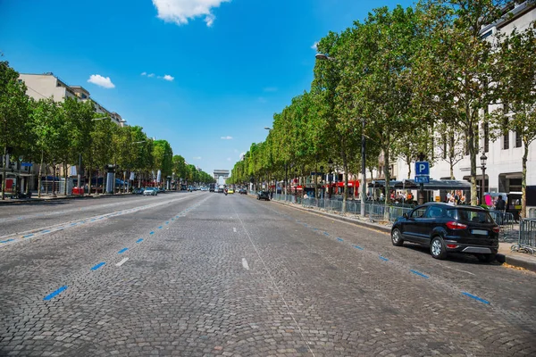 World famous Champs Elysees avenue with Arch de Triompe on the background in Paris, France