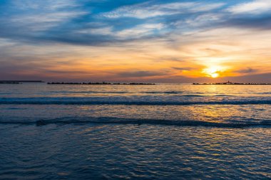 Gün batımında renkli gökyüzü altında denizin üzerinde. Sardunya, İtalya