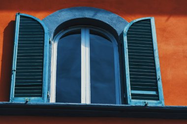 Bir pencerenin açık kepenkler turuncu bir duvar ile yakın çekim