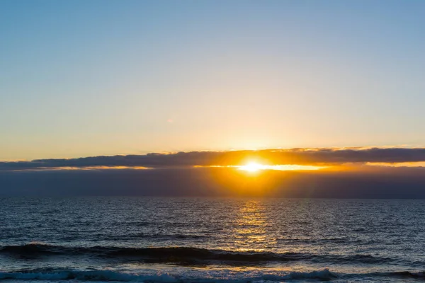 Pequeñas olas y cielo despejado en Cerdeña al atardecer —  Fotos de Stock