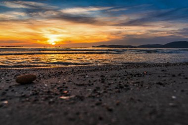 Kum ve çakıl batımında Alghero'da suların çekildiği kıyı üzerinde