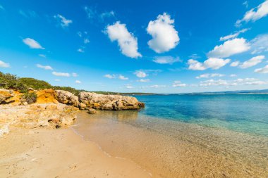 Sandy shore ile küçük bir koy Alghero'da kayalarda