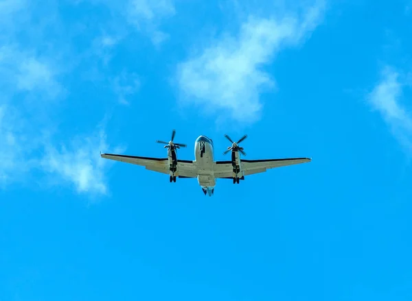 Doppelpropellerflugzeug fliegt in blauem Himmel mit Wolken — Stockfoto