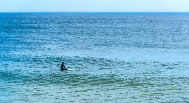Sörfçü Florida'da dalgalar bekliyor onun sörf tahtası üzerinde oturan