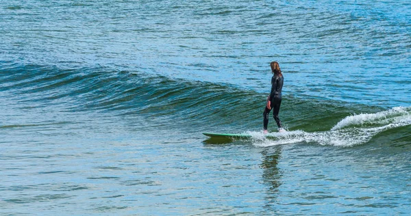 Surfer surfing a small wave on a longboard — Stock Photo, Image