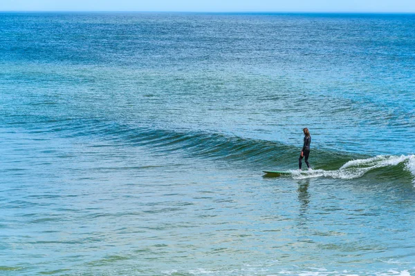 Surfer surfovat po malé vlně na dlouhé desce na Floridě — Stock fotografie