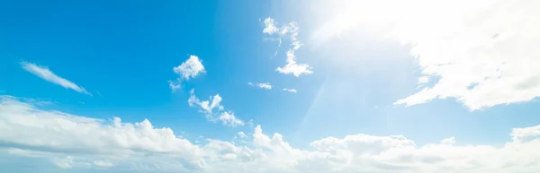 Sol brillando sobre un cielo azul con nubes blancas — Foto de Stock