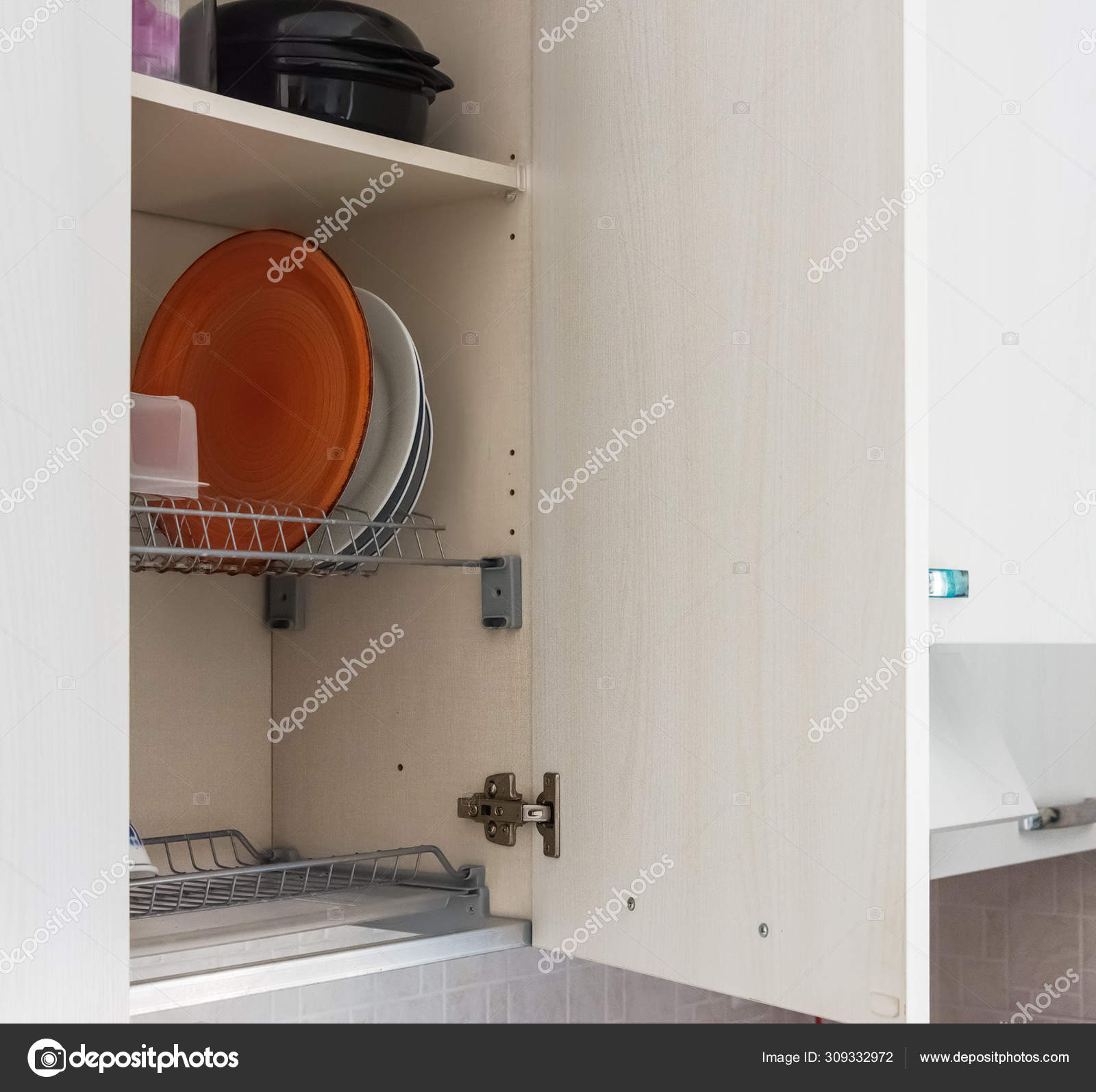 Dish Drying On A Metal Dish Rack In A White Kitchen Cabinet