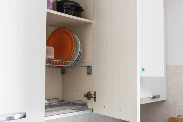 Secado de platos en un estante de metal en un gabinete de cocina — Foto de Stock