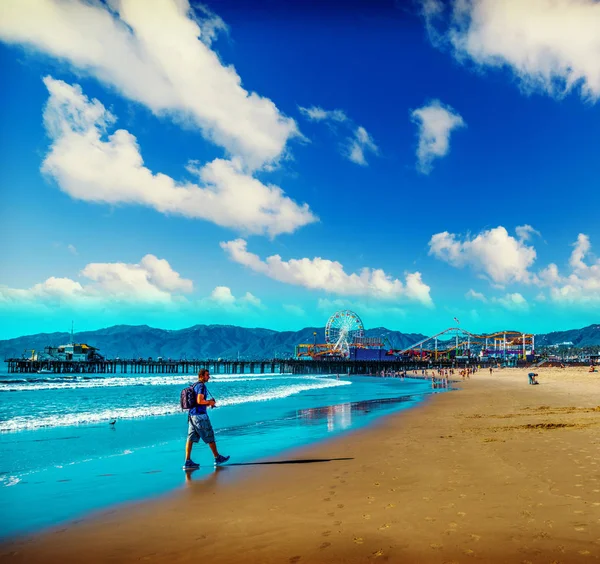 Photographer walking in world famous Santa Monica beach — Stock Photo, Image