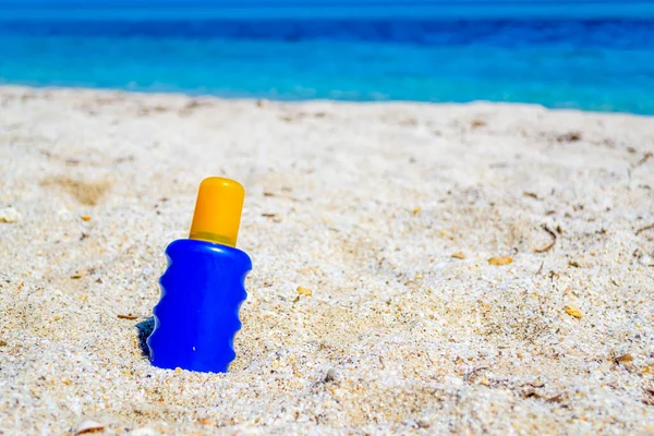 Blaue Und Gelbe Sonnenbräunungsflasche Auf Weißem Sand Sommer — Stockfoto