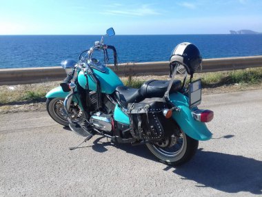 Sardunya, ITA - 14 Kasım 2020: Turkuaz Kawasaki VN 800 güneşli bir günde deniz kenarında park edilmiş