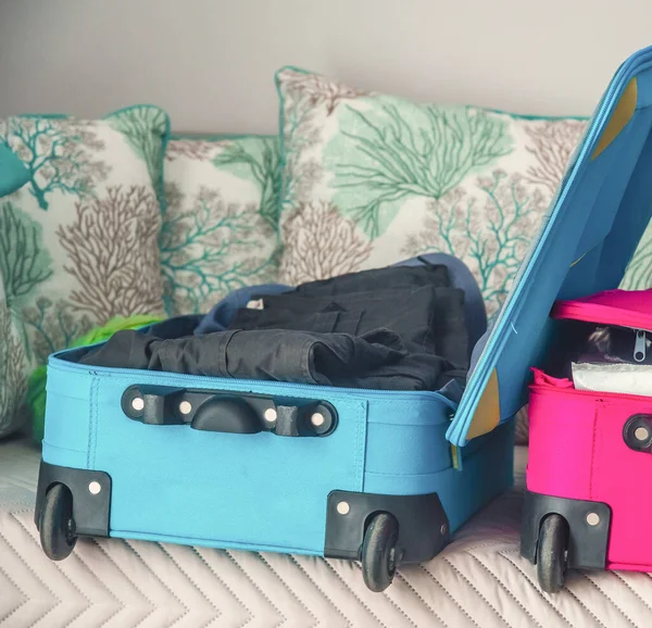 Colorful trolley suitcase open in a hotel room