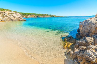 İlkbaharda Alghero sahillerinde mavi gökyüzünün altında berrak bir su. Sardunya, İtalya