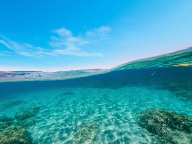 Split underwater view of Sardinia clear water under a blue sky, Italy clipart