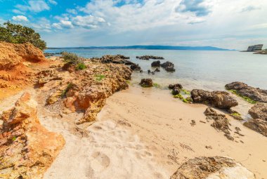 İtalya, Sardunya 'da küçük bir koyda kayalar ve kumlar