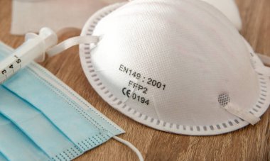 Maskeleri ve şırıngaları ahşap bir masaya kapatın.