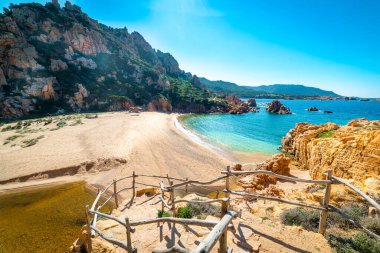 Costa Paradiso 'daki Li Cossi plajı parlayan güneşin altında. Costa Paradiso Gallura, Sardunya 'nın kuzeydoğu kıyısında yer alır. Li Cossi, Kosta Paradiso 'daki tek kumsaldır ve kıyıda yaklaşık bir kilometre uzunluğunda manzaralı bir toprak yoldan oraya ulaşabilirsiniz.