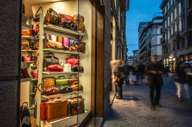 İnsanlar geceleyin Floransa, İtalya 'da lüks bir çanta dükkanının önünden geçiyor.
